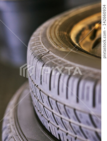 Tyres, stack and wheel in garage for repair, rubber and fixing or replace fitting on car at shop. Closeup, workshop and service or safety check as inspection, motor and alignment of vehicle to change Tyres, stack and wheel in garage for repair, rubber and fixing or replace fitting on car at shop. Closeup, workshop and service or safety check as inspection, motor and alignment of vehicle to change 142660934