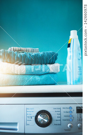 Washing machine, clothes and clean laundry in blue background with technology, product and mockup. Lens flare, fabric and digital load for energy, efficiency and furniture with fast results. Washing machine, clothes and clean laundry in blue background with technology, product and mockup. Lens flare, fabric and digital load for energy, efficiency and furniture with fast results. 142660978