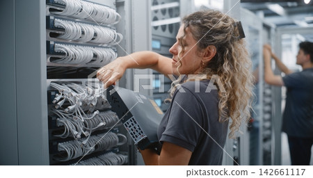 Female Data Center Engineer Replacing Network Switch in Server Rack Female Data Center Engineer Replacing Network Switch in Server Rack 142661117