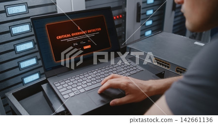 Male Network Engineer Monitoring Server Telemetry During Critical Overheating Event Male Network Engineer Monitoring Server Telemetry During Critical Overheating Event 142661136