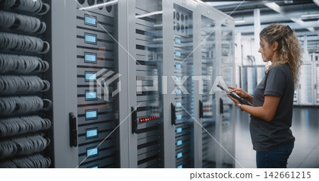 Female Data Center Engineer Inspecting Server Infrastructure with Tablet Female Data Center Engineer Inspecting Server Infrastructure with Tablet 142661215
