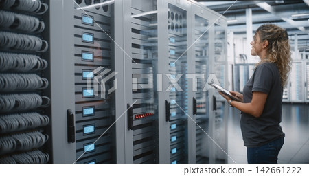 Female Data Center Engineer Inspecting Server Infrastructure with Tablet Female Data Center Engineer Inspecting Server Infrastructure with Tablet 142661222