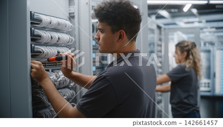 Male Data Center Engineer Replacing Network Switch in Server Rack Male Data Center Engineer Replacing Network Switch in Server Rack 142661457
