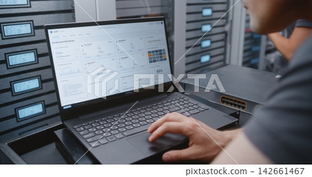 Male Cybersecurity Engineer Analyzing Critical Cyber Attack Warning in Data Center Male Cybersecurity Engineer Analyzing Critical Cyber Attack Warning in Data Center 142661467