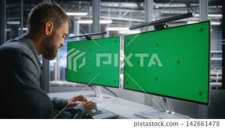 IT Professional Working with Dual Green Screen Monitors for Chroma Key Screen Replacement IT Professional Working with Dual Green Screen Monitors for Chroma Key Screen Replacement 142661478