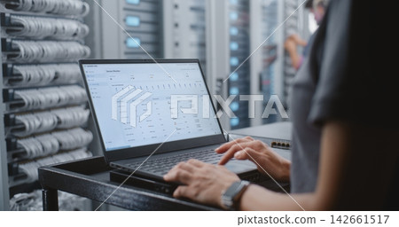 Female Engineer Responding to Critical Server Overheating Alert in Data Center Female Engineer Responding to Critical Server Overheating Alert in Data Center 142661517