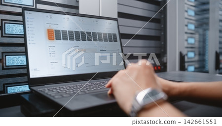 IT Specialist Analyzing Data Center Incident Dashboard and Server Performance Metrics IT Specialist Analyzing Data Center Incident Dashboard and Server Performance Metrics 142661551