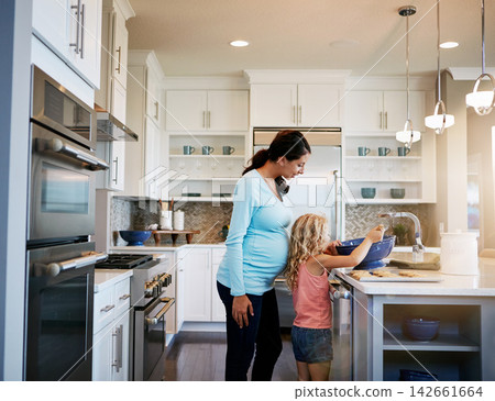 Mother, daughter and cookies or helping with baking in kitchen for teaching, cooking and bonding in home. Family, pregnant woman and girl with learning to cook a cake and sweet snack in apartment Mother, daughter and cookies or helping with baking in kitchen for teaching, cooking and bonding in home. Family, pregnant woman and girl with learning to cook a cake and sweet snack in apartment 142661664