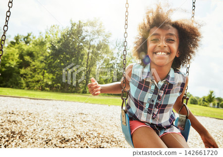 African girl, portrait and smile with swing, park and nature for outdoor fun or play with fresh air. Child, joy and playground with summer, freedom and school holiday or break outside with happiness African girl, portrait and smile with swing, park and nature for outdoor fun or play with fresh air. Child, joy and playground with summer, freedom and school holiday or break outside with happiness 142661720
