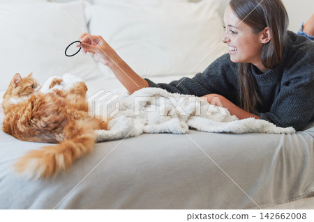 Love, happy and woman playing with cat in bedroom of home for bonding or fun as pet owner. Bed, smile and toys with person teasing adorable kitten in apartment for morning or winter relaxation Love, happy and woman playing with cat in bedroom of home for bonding or fun as pet owner. Bed, smile and toys with person teasing adorable kitten in apartment for morning or winter relaxation 142662008