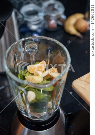 Blender, diet and fruit with vegetables for smoothie in kitchen for nutrition, health or wellness. Breakfast, detox and produce in equipment for fresh, natural or organic juice with vitamins at home. Blender, diet and fruit with vegetables for smoothie in kitchen for nutrition, health or wellness. Breakfast, detox and produce in equipment for fresh, natural or organic juice with vitamins at home. 142662011
