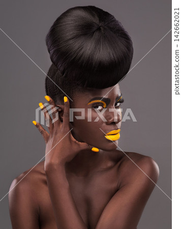 African, model and studio colors for makeup, beauty and creative yellow lipstick. Bold, woman and skin with confidence, dramatic hair and bun for glamour or trendy cosmetics on grey studio background 142662021