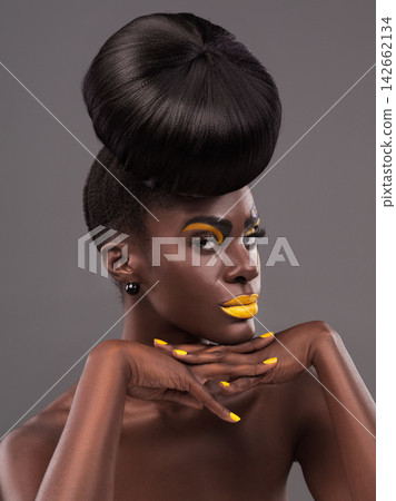 African, model and edgy portrait with makeup, beauty and creative yellow lipstick. Bold, woman and skin with confidence, dramatic hair and bun for glamour and trendy cosmetics on grey background African, model and edgy portrait with makeup, beauty and creative yellow lipstick. Bold, woman and skin with confidence, dramatic hair and bun for glamour and trendy cosmetics on grey background 142662134