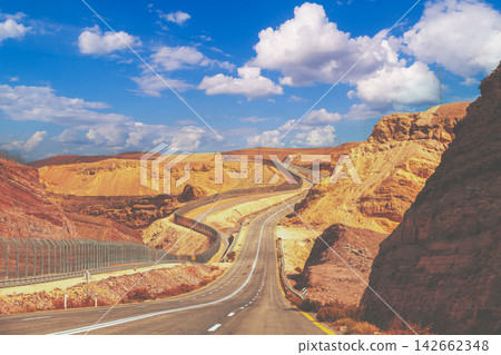Driving a car on mountain Israel road. Desert landscape. Empty road. The road runs along the border of Israel with Egypt. View from the car of the mountain landscape on a sunny day. Israel Driving a car on mountain Israel road. Desert landscape. Empty road. The road runs along the border of Israel with Egypt. View from the car of the mountain landscape on a sunny day. Israel 142662348
