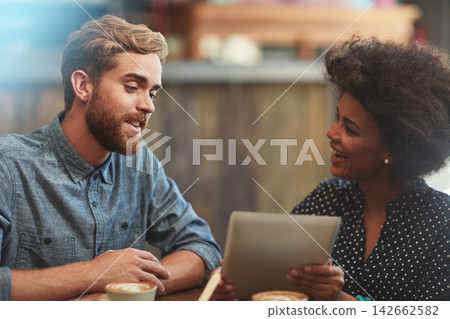 Couple, tablet and happy on date in coffee shop with social media streaming, bonding and online information. Interracial, people and laughing in cafe for funny post update, comic discussion and relax Couple, tablet and happy on date in coffee shop with social media streaming, bonding and online information. Interracial, people and laughing in cafe for funny post update, comic discussion and relax 142662582