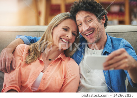 Couple, selfie and sofa in home, smile and excited for memory with bonding for love with connection. People, man and woman with embrace for care, happy and profile picture on app for social network Couple, selfie and sofa in home, smile and excited for memory with bonding for love with connection. People, man and woman with embrace for care, happy and profile picture on app for social network 142662823