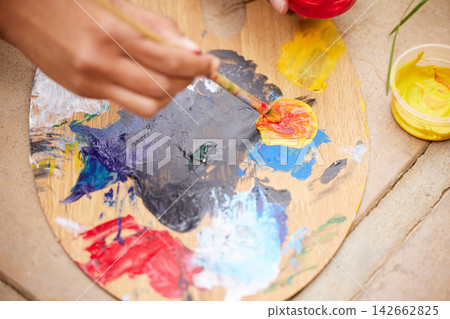 Person, hand and paint palette as creative for art therapy or watercolor hobby, talent or expression. Fingers, tools and top view of acrylic in studio workshop for handmade craft, learning or class Person, hand and paint palette as creative for art therapy or watercolor hobby, talent or expression. Fingers, tools and top view of acrylic in studio workshop for handmade craft, learning or class 142662825