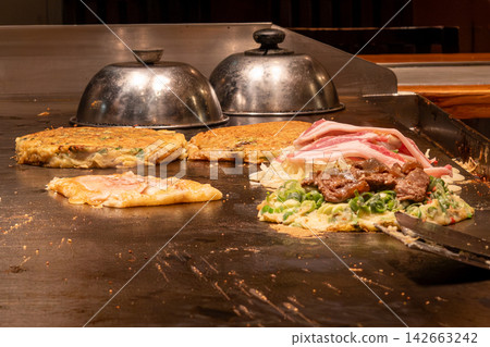 Delicious okonomiyaki is being prepared. Delicious okonomiyaki is being prepared. 142663242