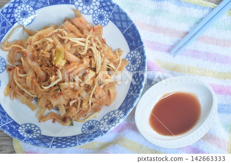 Pad Thai stir fried rice noodles with egg and bean sprout couple garlic chive on plate dipping chili sauce Pad Thai stir fried rice noodles with egg and bean sprout couple garlic chive on plate dipping chili sauce 142663333