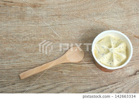 vanilla chocolate chip flavor ice cream in paper cup with wooden spoon on table vanilla chocolate chip flavor ice cream in paper cup with wooden spoon on table 142663334