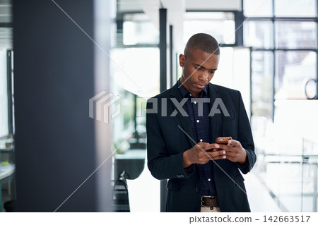Businessman, smartphone notification and texting in office for communication, internet news or job post. Black person, mobile tech and typing in workplace for social media and online research Businessman, smartphone notification and texting in office for communication, internet news or job post. Black person, mobile tech and typing in workplace for social media and online research 142663517