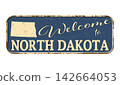 Welcome to North Dakota. A worn blue plaque with the name and outline of the state 142664053