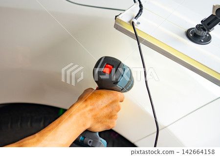 Removing dents on the car. PDR technology. Car body repair without painting. Removing dents on the car. PDR technology. Car body repair without painting. 142664158