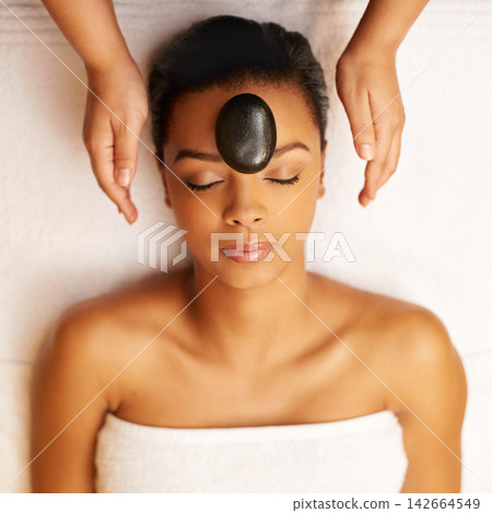 Top view, stone and woman with massage, beauty and relaxing with stress relief, treatment and wellness. Person, hands and rock with girl, body luxury and vacation with care, wellbeing and peaceful Top view, stone and woman with massage, beauty and relaxing with stress relief, treatment and wellness. Person, hands and rock with girl, body luxury and vacation with care, wellbeing and peaceful 142664549