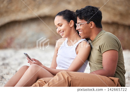 Beach, couple and vacation together with smartphone, typing and social media or online browse on mobile. Getaway, blog and summer holiday post and outside, smile and happy for love or relax on sand Beach, couple and vacation together with smartphone, typing and social media or online browse on mobile. Getaway, blog and summer holiday post and outside, smile and happy for love or relax on sand 142665722