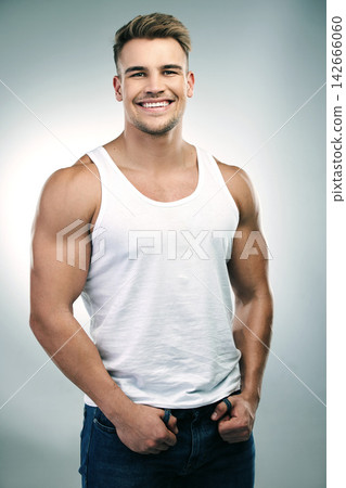Man, happy and portrait in white background or funny with humour while joking in a tank top, fashion and wellness for care. Male model, muscular body or vest and smile for fitness or health in studio Man, happy and portrait in white background or funny with humour while joking in a tank top, fashion and wellness for care. Male model, muscular body or vest and smile for fitness or health in studio 142666060