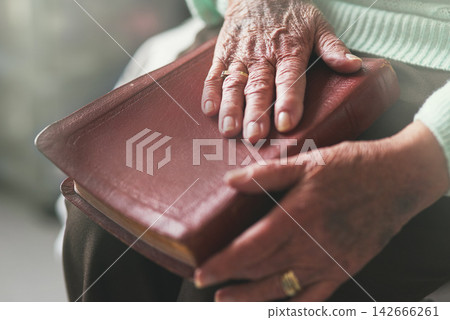Senior woman, hand and bible with prayer for worship, faith and spiritual healing at home. God, support and elderly person with religious book in house for scripture, testament and Christian wisdom Senior woman, hand and bible with prayer for worship, faith and spiritual healing at home. God, support and elderly person with religious book in house for scripture, testament and Christian wisdom 142666261
