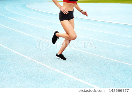 Woman, cropped and arena for running or sport on track, training or exercise for wellness. Female athlete, stadium and runner for freedom or health in sunshine, commitment and strong with cardio Woman, cropped and arena for running or sport on track, training or exercise for wellness. Female athlete, stadium and runner for freedom or health in sunshine, commitment and strong with cardio 142666577