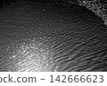 A dazzling platinum reflection shines brightly on the jet-black surface of the sea. 142666623