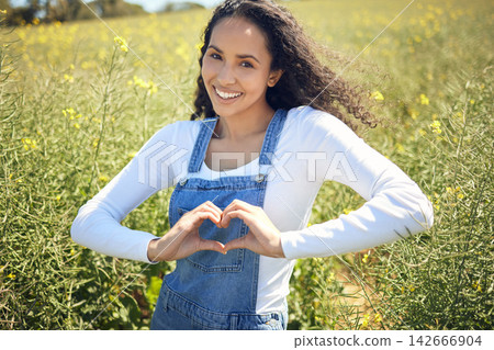 Woman, portrait and smile with field, nature and flowers with heart emoji for sustainable farming. Farmer, agriculture and ecology with meadow, environment or ecology for carbon capture or green love Woman, portrait and smile with field, nature and flowers with heart emoji for sustainable farming. Farmer, agriculture and ecology with meadow, environment or ecology for carbon capture or green love 142666904