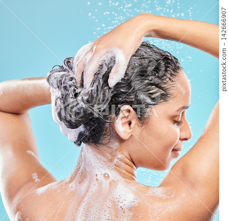 Back, shower and woman with skincare, wellness and hair care on blue studio background. Rear view, person and model with water drops, wet or beauty with liquid, grooming routine and foam with hygiene Back, shower and woman with skincare, wellness and hair care on blue studio background. Rear view, person and model with water drops, wet or beauty with liquid, grooming routine and foam with hygiene 142666907