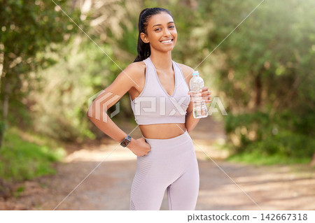 Woman, bottle and outdoor in portrait with smile for exercise, workout or running in the forest. Happy, female person or athlete in nature for fitness, training and health with water drink to relax Woman, bottle and outdoor in portrait with smile for exercise, workout or running in the forest. Happy, female person or athlete in nature for fitness, training and health with water drink to relax 142667318