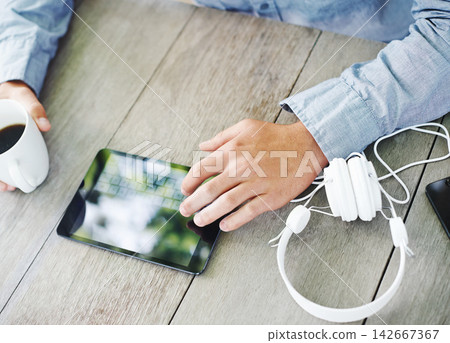 Table, coffee and hand with typing on tablet for communication, social media or online search. High angle, morning and man with digital technology on desk for text message, networking or connectivity Table, coffee and hand with typing on tablet for communication, social media or online search. High angle, morning and man with digital technology on desk for text message, networking or connectivity 142667367