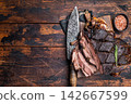 Slow ccoked sliced Venison leg, roasted game meat of deer on a board with herbs. wooden background. top view 142667599
