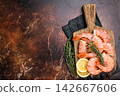 Fresh raw Headless Red Argentine shrimps, Prawns on wooden board. brown background. top view 142667606