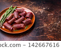 Typical dried spanish meat cecina, spanish beef jamon on plate with rosemary. brown background. top view 142667616