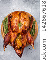 Baked whole duck with apples on wooden board. grey background. top view 142667618