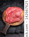 Butcher board with raw beef cheeks, uncooked meat. black background. top view 142667625