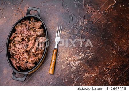 Slow Cooked Pulled Beef, Traditional meat rubbed with spices and smoked. brown background. top view Slow Cooked Pulled Beef, Traditional meat rubbed with spices and smoked. brown background. top view 142667626