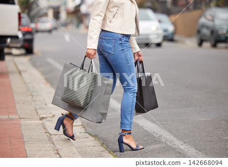 Fashion, shopping bag and legs of woman in street with product, commute and retail therapy with financial freedom. Feet, walking and girl in city with package for discount sale at designer boutique. Fashion, shopping bag and legs of woman in street with product, commute and retail therapy with financial freedom. Feet, walking and girl in city with package for discount sale at designer boutique. 142668094