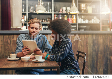 Couple, tablet and laughing or smile in coffee shop with social media meme, bonding and funny online information. Interracial, people and happy in cafe with tech for comic post update or mockup space Couple, tablet and laughing or smile in coffee shop with social media meme, bonding and funny online information. Interracial, people and happy in cafe with tech for comic post update or mockup space 142669042