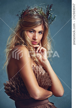 Portrait, beauty and woman with flower crown for fashion in studio isolated on blue a background. Face, wreath and confident person in makeup for skin, hair or natural cosmetics with body in dress 142669047