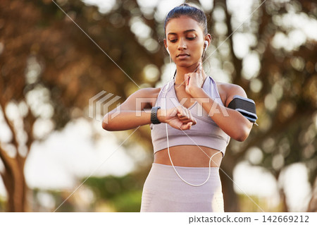 Woman, time and headphones with pulse in outdoor for training, sports or fitness for wellness. Female runner, feeling and heart rate with cardio in nature for health, goals with smart watch app Woman, time and headphones with pulse in outdoor for training, sports or fitness for wellness. Female runner, feeling and heart rate with cardio in nature for health, goals with smart watch app 142669212