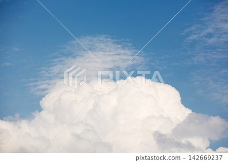 Large fluffy white cumulus cloud growing under blue sky Large fluffy white cumulus cloud growing under blue sky 142669237