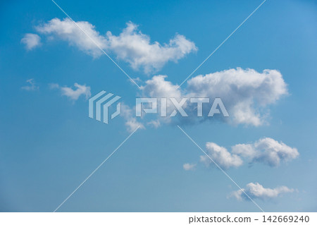 Scattered white fluffy cumulus clouds on clear blue sky background 142669240