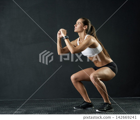Fitness, squat and sports woman in studio for leg muscle exercise, balance or strength on dark background. Strong, athlete and female person for performance workout, glutes training or body goals Fitness, squat and sports woman in studio for leg muscle exercise, balance or strength on dark background. Strong, athlete and female person for performance workout, glutes training or body goals 142669241